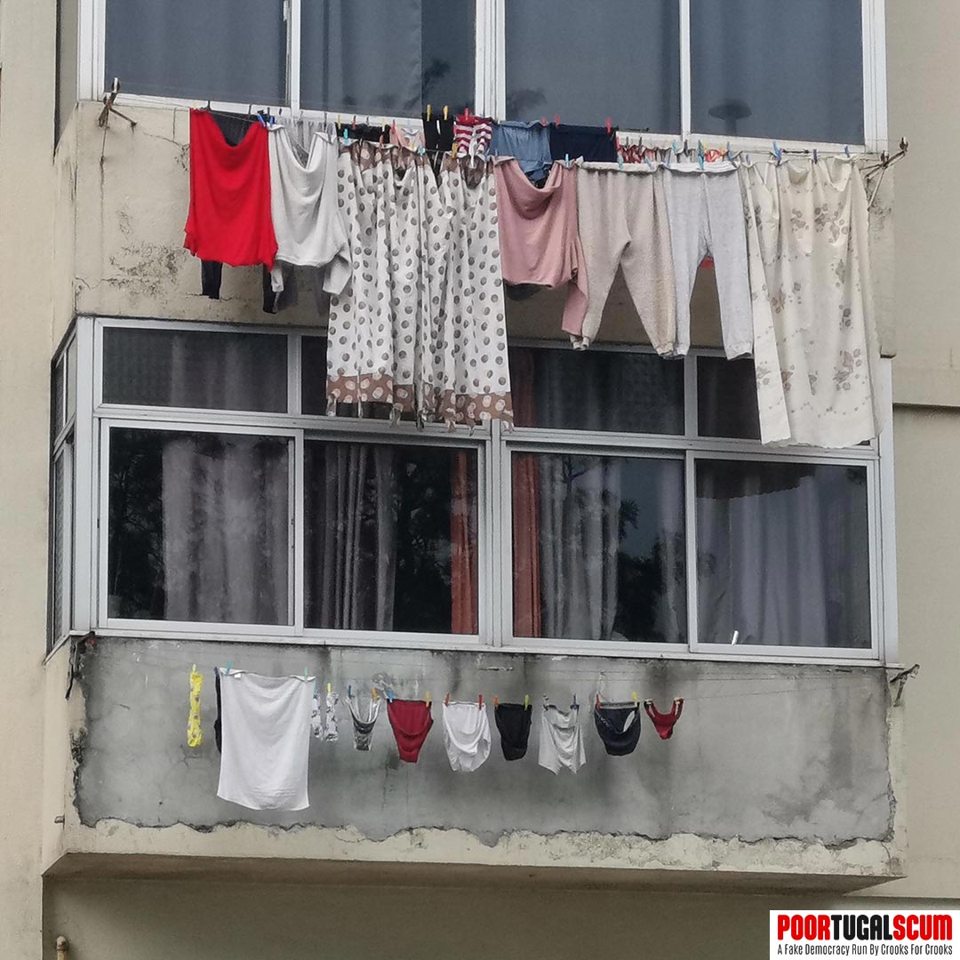 Clothes hanging from the windows of buildings in Portugal